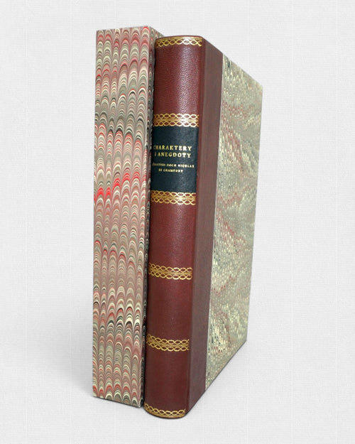 Charaktery i anegdoty Chamforta – luksusowe wydanie w skórzanej oprawie ze złoceniami, ustawione obok ozdobnego, marmurkowego etui ochronnego