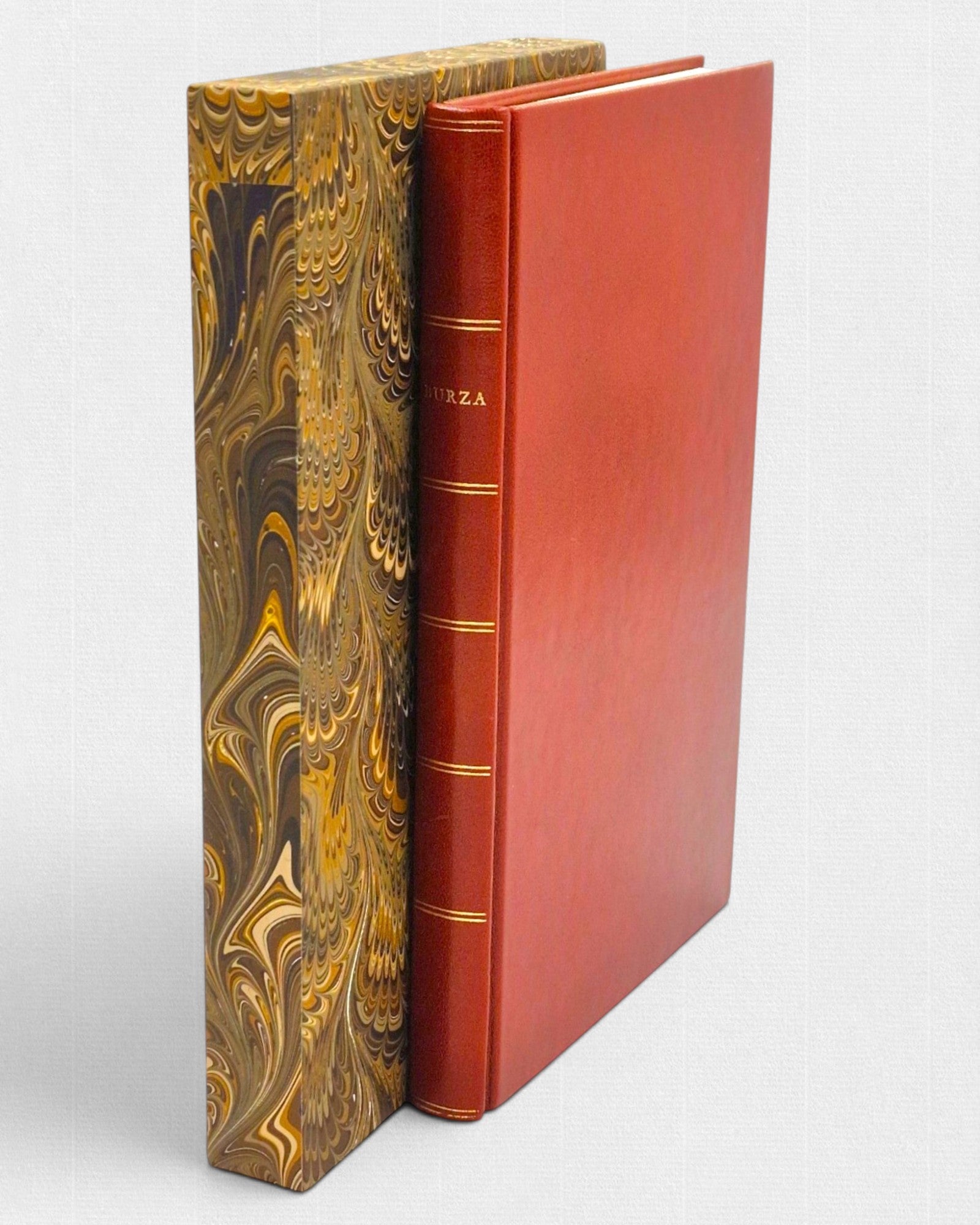 Ekskluzywne wydanie „Burzy” Williama Szekspira w czerwonej, ręcznie wykonanej oprawie skórzanej z tłoczonym grzbietem, zestawione z ozdobnym, marmurkowym etui.