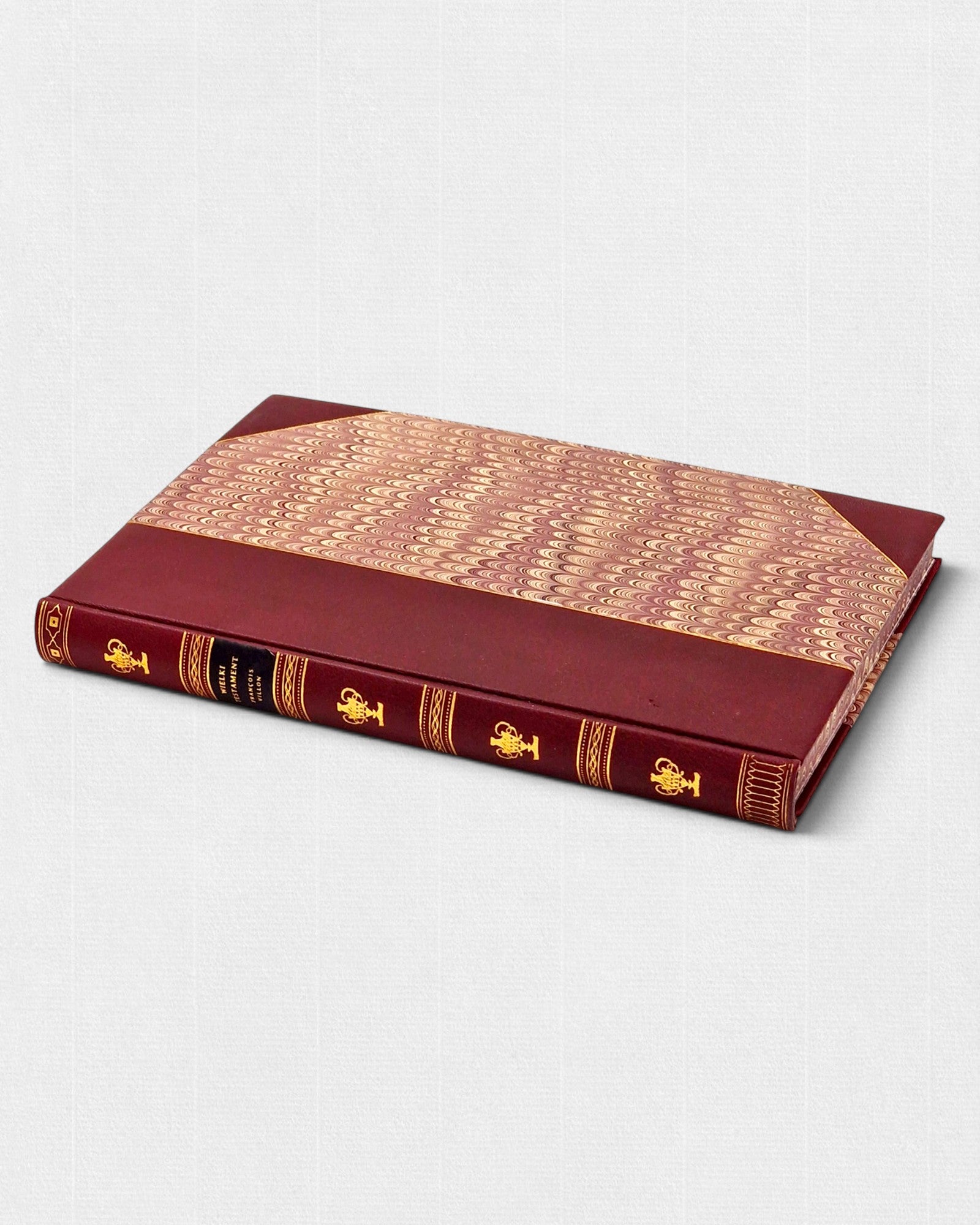 Ekskluzywne wydanie „Wielkiego Testamentu” François Villona w ręcznej oprawie półskórkowej, z marmurkowanymi okładzinami i złoconym grzbietem, widok z góry.