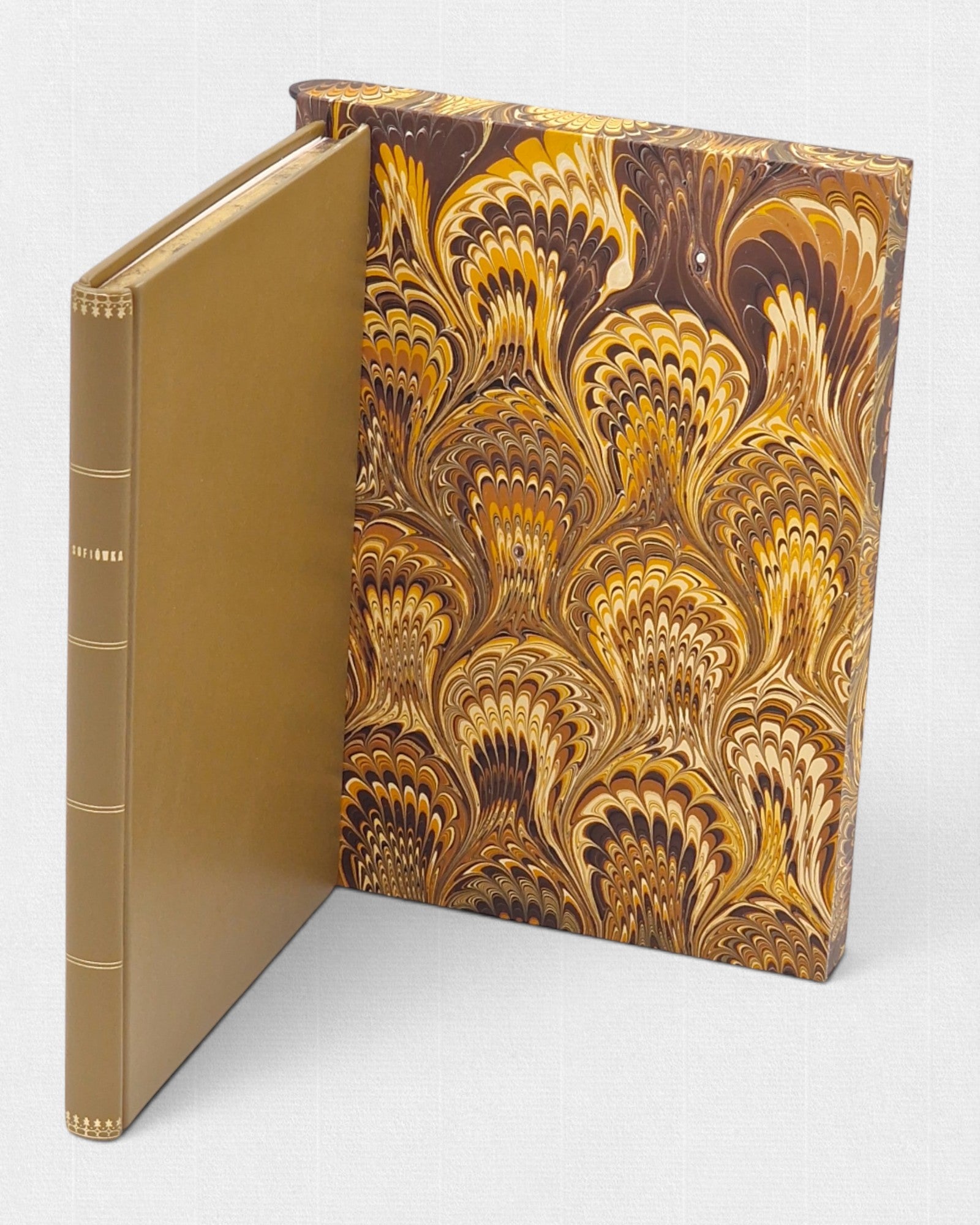 Luksusowe wydanie „Sofiówki” Stanisława Trembeckiego – książka w złotej, skórzanej oprawie z tłoczonym grzbietem, umieszczona obok dekoracyjnego etui z marmoryzowanego papieru w odcieniach brązu i złota.
